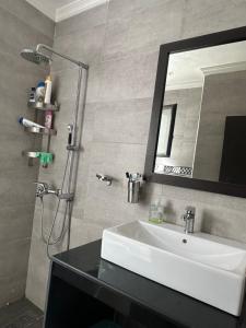 a bathroom with a sink and a shower with a mirror at Séjour chez habitant in Rabat
