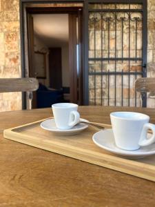 two cups of coffee sitting on a wooden table at Il Borgo Delle Querce Villa Fichi Piscina privata in Martina Franca
