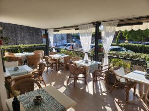 a patio with tables and chairs on a balcony at Hotel Marina in Torri del Benaco