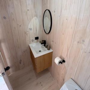 a bathroom with a sink and a mirror at Costa Lodge Pichilemu in Pichilemu