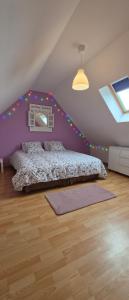 a bedroom with a bed and a purple wall at Gîte Côte et Terre in Questrecques