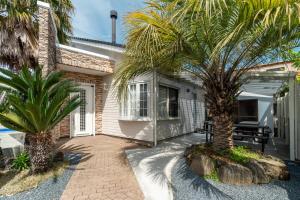a house with two palm trees in front of it at Seasiders in Ichinomiya
