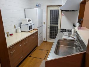 a small kitchen with a sink and a microwave at Seasiders in Ichinomiya