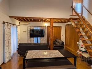 a living room with a couch and a table at Seasiders in Ichinomiya