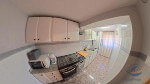 a small kitchen with white cabinets and a stove at casadelsol in Caravaca de la Cruz