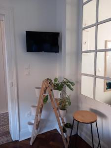 a room with a ladder and a tv on a wall at A la ferme chez Christian in Escaudoeuvres