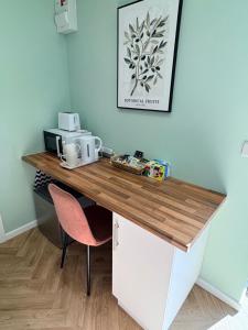 a desk in a room with a pink chair at Clover Road Guest Suite in Swaffham +3 photos