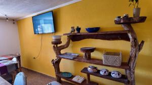 a room with wooden shelves and a yellow wall at El Rancho B&B in San Pedro de Atacama