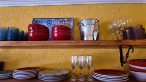 a shelf with plates and wine glasses on it at El Rancho B&B in San Pedro de Atacama