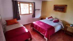 a bedroom with two beds and a window at El Rancho B&B in San Pedro de Atacama