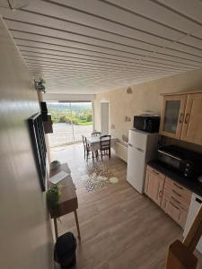 a kitchen and dining room with a table and refrigerator at gîte 8 personnes avec jacuzzi privé et étang de pêche en Normandie in Montabot