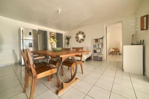 a dining room with a table and a refrigerator at villa vue mer logements indépendants piscine privative in Grand-Bourg