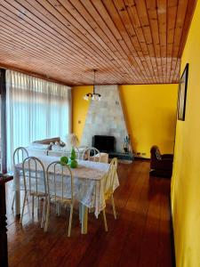 a dining room with a white table and chairs at Recanto MJ in Campos do Jordão