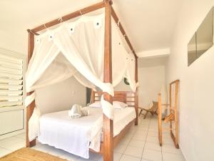 a bedroom with a canopy bed in a room at villa vue mer logements indépendants piscine privative in Grand-Bourg
