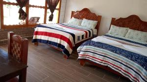 a bedroom with two beds and a table at cabañas liquidambar in La Trinitaria