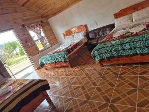 a bedroom with two beds and a tiled floor at cabañas liquidambar in La Trinitaria