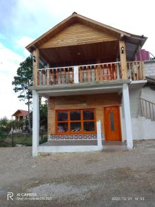 a house with a balcony on top of it at cabañas liquidambar in La Trinitaria