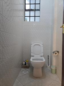 a bathroom with a toilet and a window at Mina Luxe Machakos in Machakos