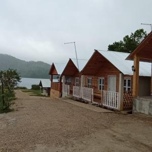 a row of wooden houses on a dirt road at cabañas liquidambar in La Trinitaria