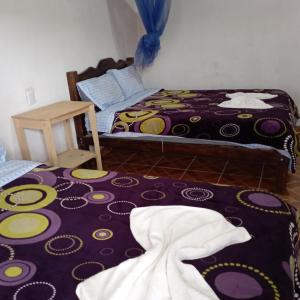 a room with two beds and a purple rug at cabañas liquidambar in La Trinitaria +9 photos