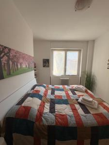a bedroom with a bed with a colorful quilt on it at VALTELLINA SONDRIO HOLIDAYS in Sondrio
