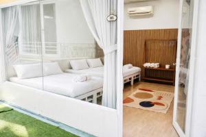 a living room with a white couch and a window at Home Sake Hòn Sơn in Lai Sơn +17 photos