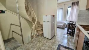 a kitchen with a refrigerator and a staircase at Julieta's house in Chios +3 photos
