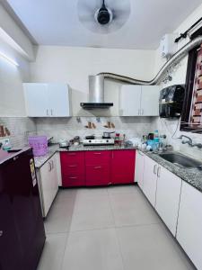 a kitchen with red cabinets and a red sink at Homely stayy in Mohali
