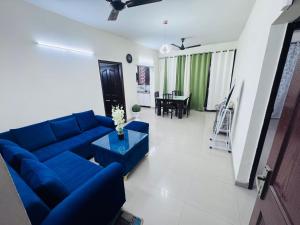 a living room with a blue couch and a table at Homely stayy in Mohali