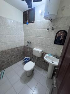 a bathroom with a toilet and a sink at Homely stayy in Mohali