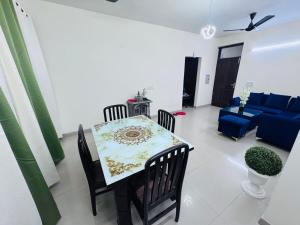 a dining room and living room with a table and chairs at Homely stayy in Mohali +7 photos