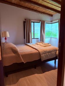 a bedroom with a large bed with two windows at Barcena Houses in Tumbaya