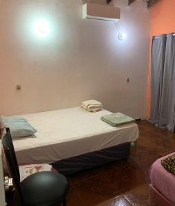 a small room with a bed and a chair at Habitación 4 in Asunción