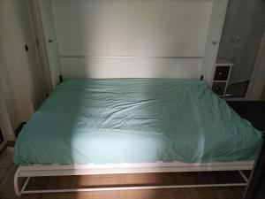 a bed with a green comforter in a room at Agréable studio indépendant proche mer in Saint-Hilaire-de-Riez
