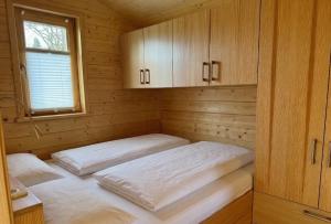 two beds in a sauna with a window and cabinets at 101 Tiny House Elbhütte mit Wiesenblick in Bleckede