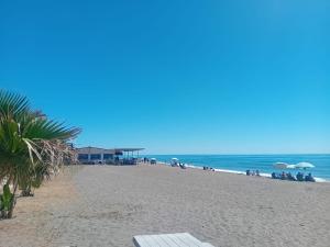 a beach with people sitting under umbrellas and the ocean at Apartamento Bahía Sol in Rincón de la Victoria