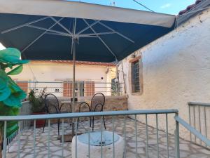 a patio with a table and chairs under an umbrella at Rodomelo Cute Studio 3 in Leonidio