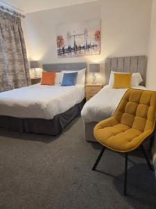 a room with two beds and a chair in it at Blackrock Carole Ville Guesthouse in Cork