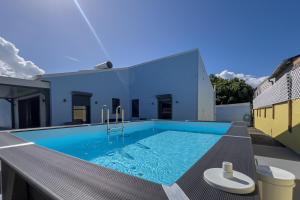 a swimming pool in the backyard of a house at Villa Coeur Bleu in Petit-Bourg