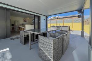 an outdoor patio with a table and chairs at Villa Coeur Bleu in Petit-Bourg