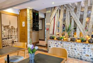 a restaurant with tables and chairs and a wall with wooden beams at Entre Terre Et Mer in Honfleur