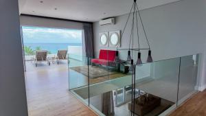 a living room with a glass table and a red couch at Vetho House Villa Ballito in Ballito