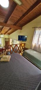 a bedroom with a bed and a flat screen tv at Cabañas Rancho Unelen in Colón