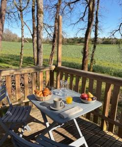 a table with a bowl of fruit on a deck at La Rosée du Cardou in Gavaudun