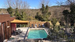 a small swimming pool with chairs and a table at Villa Les Vignes in Salavas