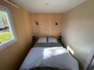 a small bed in a small room with a window at La Rosée du Cardou in Gavaudun