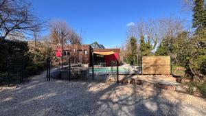 a gate to a house with a swimming pool at Villa Les Vignes in Salavas