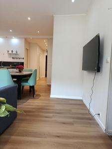 a living room with a table and a tv on a wall at Appartement 2 in Aubigny-sur-Nère