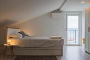 a bedroom with a bed and a large window at Guesthouse Podaca in Podaca