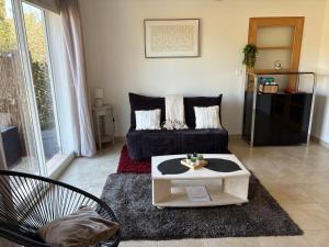 a living room with a couch and a coffee table at Appartement Romana PUISSALICON 34 in Puissalicon